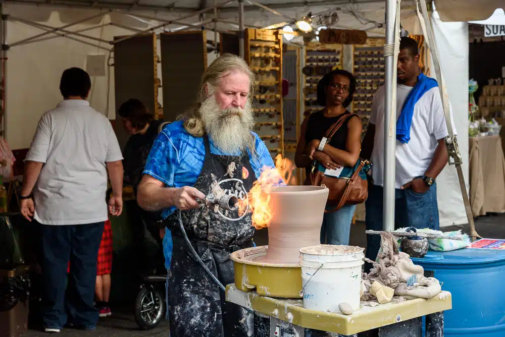 A potter shaping clay on a wheel